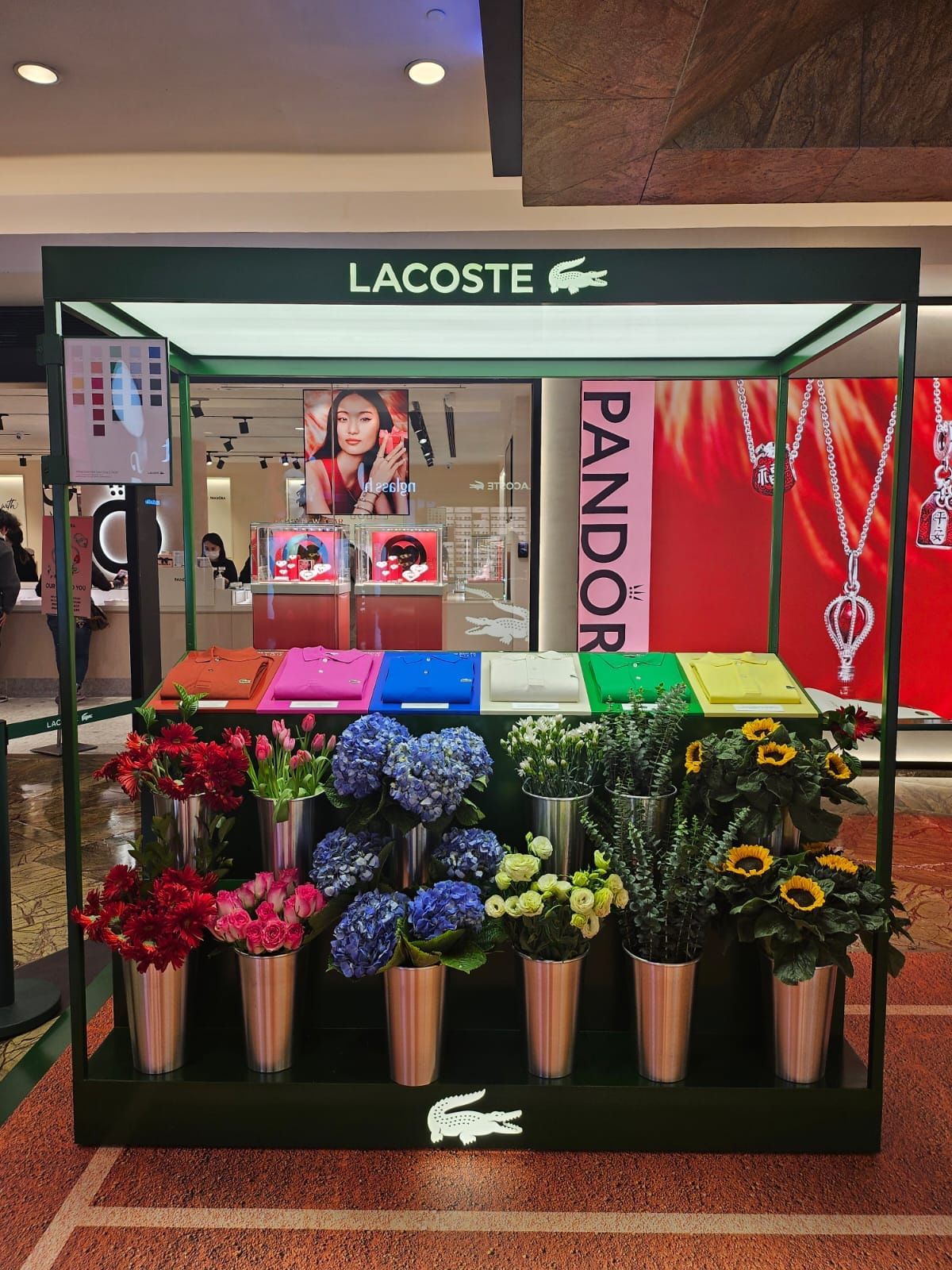 Flower kiosk pairing colourful Lacoste polo displays with bouquets